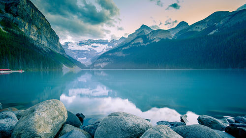 Scenic view of lake by mountains against sky