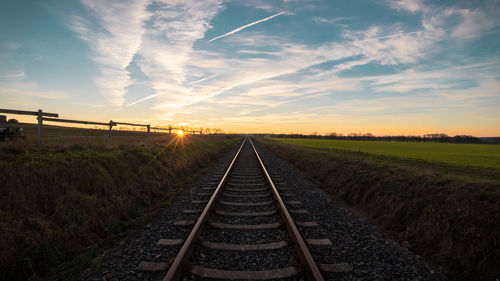 View of railroad tracks on field against sky