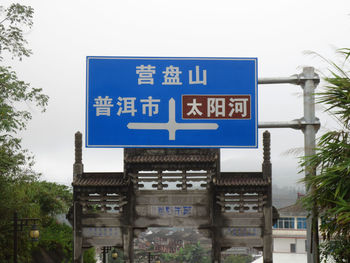 Low angle view of road sign against blue sky