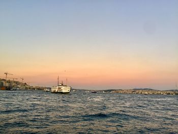 Sailboat sailing on sea against sky during sunset