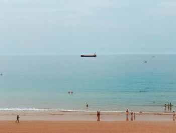 People on beach against sky