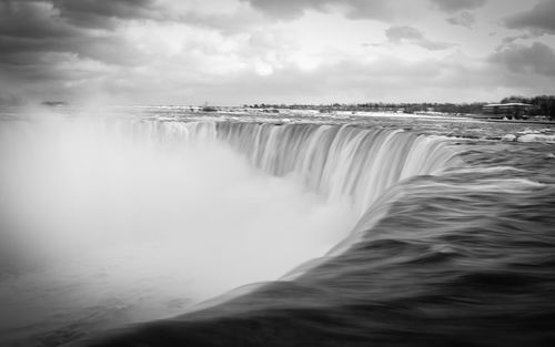 Scenic view of waterfall against sky