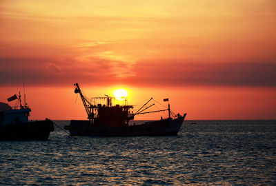 Silhouette ship in sea against sky during sunset