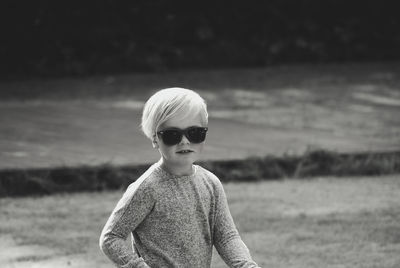 Boy wearing sunglasses while standing on land