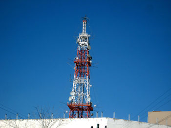 Low angle view of communications tower against clear blue sky