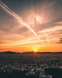 Aerial view of city against orange sky