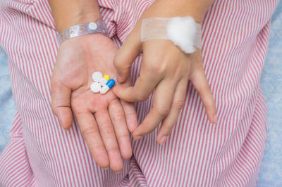 Midsection of patient holding medicines at hospital
