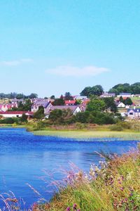 Scenic view of river with houses in background