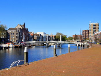 River amidst buildings against clear blue sky