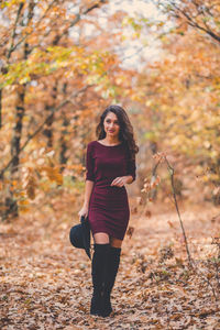 Portrait of a young woman standing in autumn