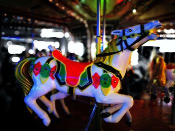 Close-up of illuminated carousel hanging in amusement park