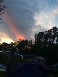 Cars on road against cloudy sky at sunset