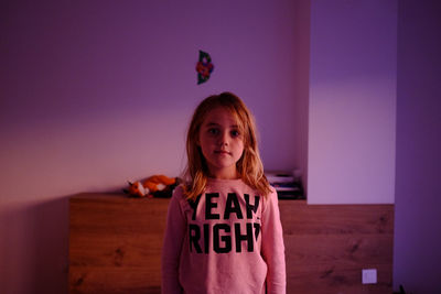 Portrait of girl standing against wall