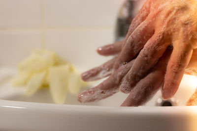 Close-up of woman preparing food in plate