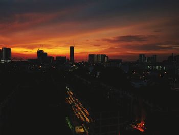 Illuminated buildings against sky during sunset