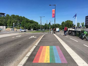 People on road against blue sky