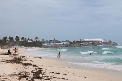 People on beach against sky