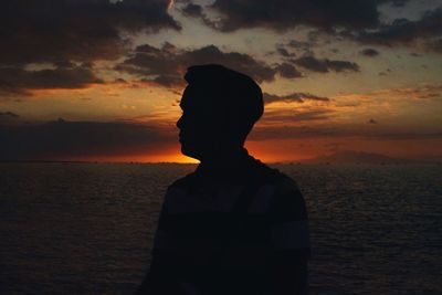 Silhouette man against sea during sunset