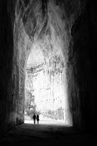 Silhouette people standing in cave
