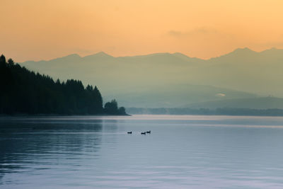 A beautiful sunrise over the lake with mountains in distance. morning landscape in warm tones.