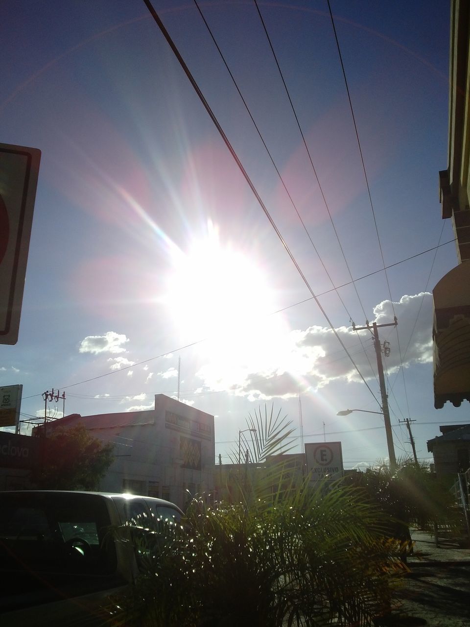 sun, building exterior, built structure, architecture, sunbeam, sunlight, lens flare, power line, sky, city, electricity pylon, car, transportation, cable, low angle view, street, sunny, mode of transport, land vehicle, building