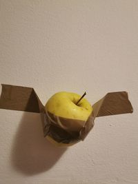 Close-up of fruit on table against wall