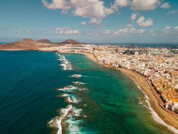 High angle view of townscape by sea against sky