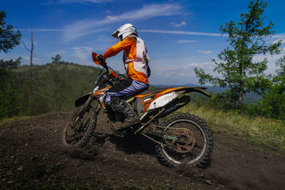 Enduro motorcycle racer riding dusty trail