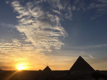 Silhouette of building against cloudy sky during sunset