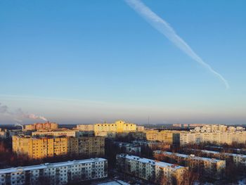 Buildings in city against blue sky