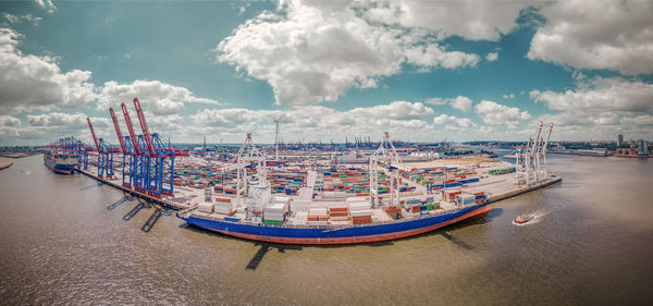 Panoramic view of boats moored at harbor against sky