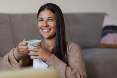 Portrait of a smiling young woman drinking drink