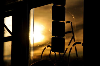 Close-up of silhouette camera against sky during sunset