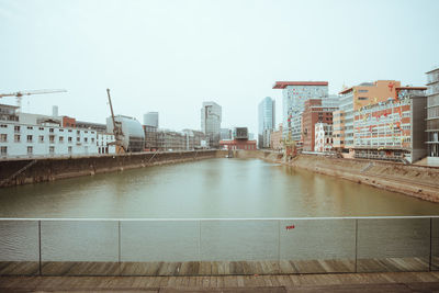 Bridge over lake against buildings in city