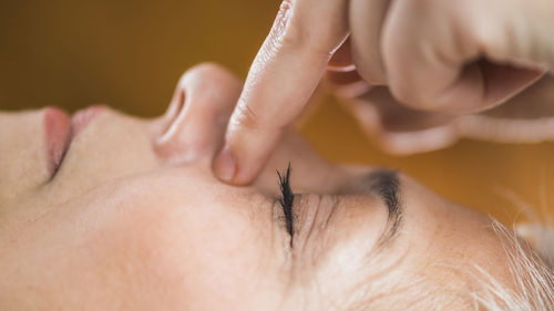 Close-up of hands massaging woman nose