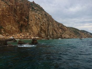 Scenic view of rocks in sea against sky