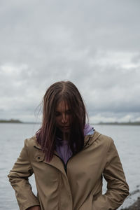 Portrait of woman standing in sea against sky