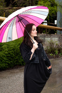 Rear view of woman holding umbrella