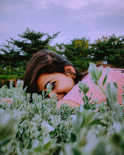 Portrait of woman lying down on plants