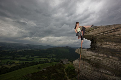 Female rock climber on cliff at the peak district in england