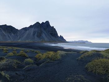 Scenic view of sea and mountains against sky