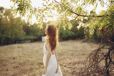 Rear view of woman standing on field