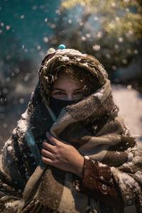 Portrait of boy looking at frozen tree