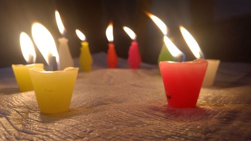 Close-up of illuminated candles on table at home