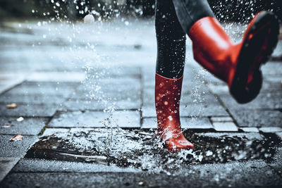 Low section of person standing on wet floor during rainy season