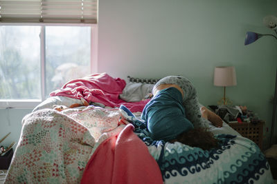 Bored girl lying on bed at home