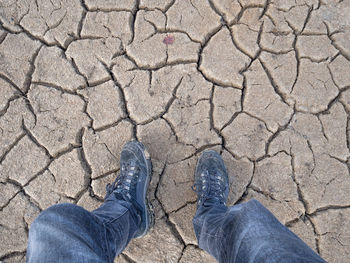 Low section of man walking on parched soil
