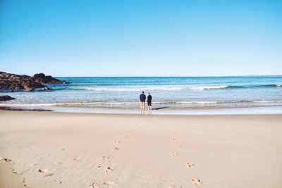 Couple standing on calm beach