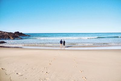 Rear view of man standing on beach