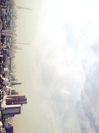 Buildings in city against cloudy sky